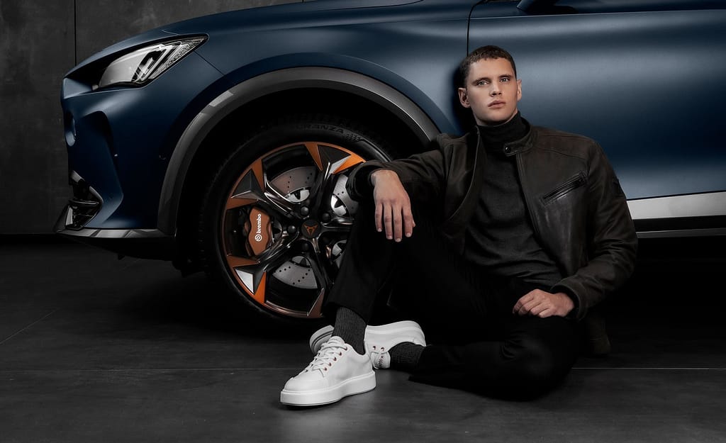un ragazzo indossa le mikakus seduto vicino ad una Cupra