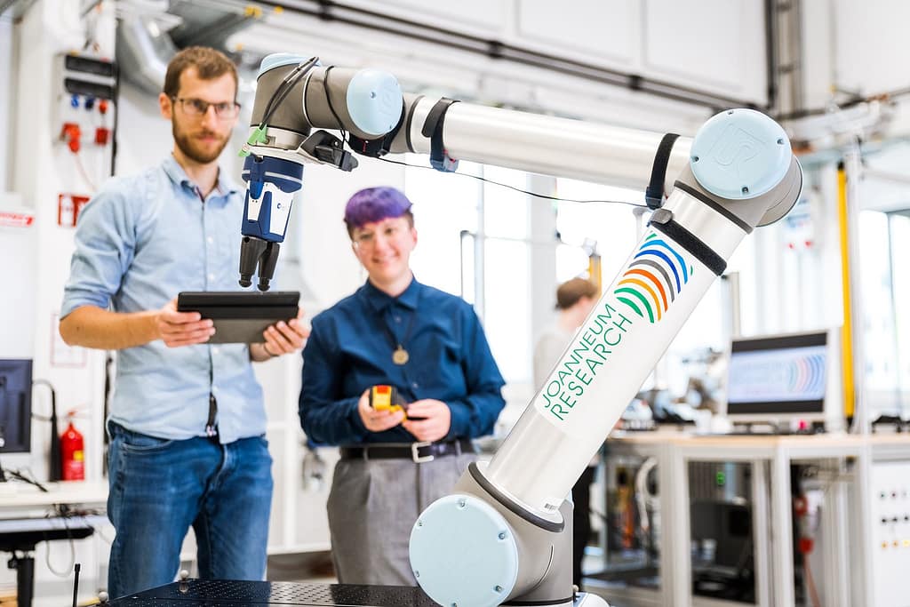 due ragazzi con un robot, industria microelettronica in Carinzia