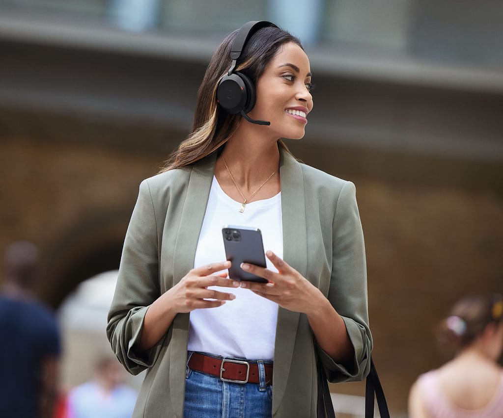 una donna lavora con suo smartphone e le cuffie Jabra