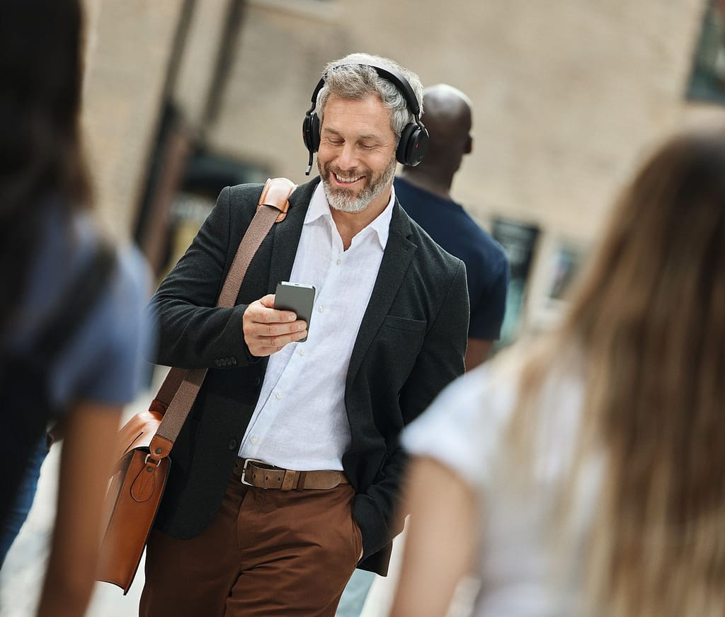 un umo lavora con suo smartphone e le cuffie Jabra