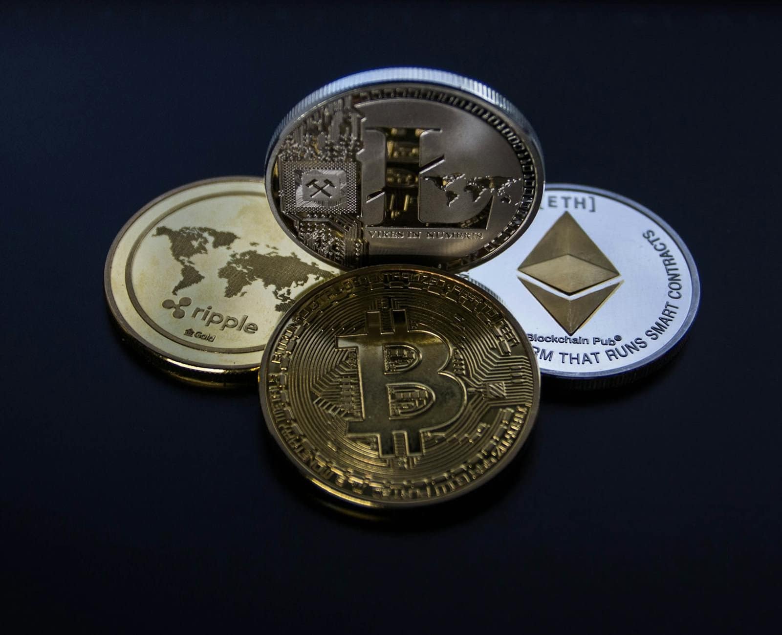 four assorted cryptocurrency coins