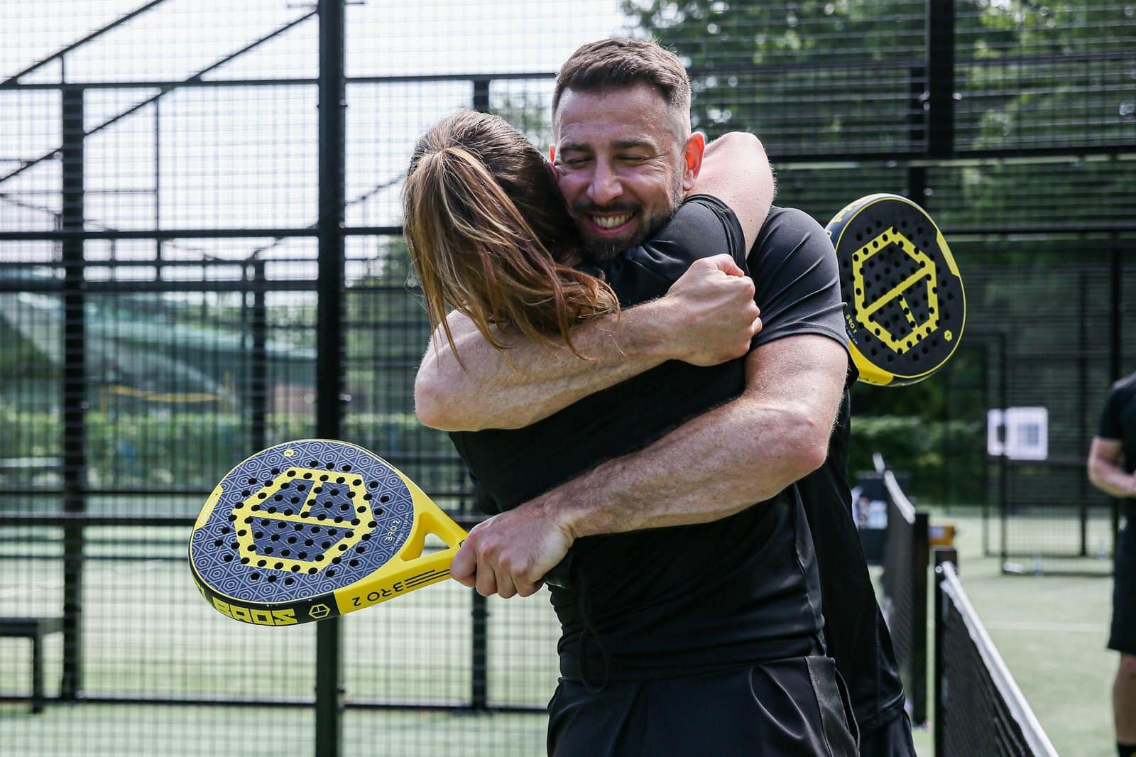 pair of tennis players hugging on the court