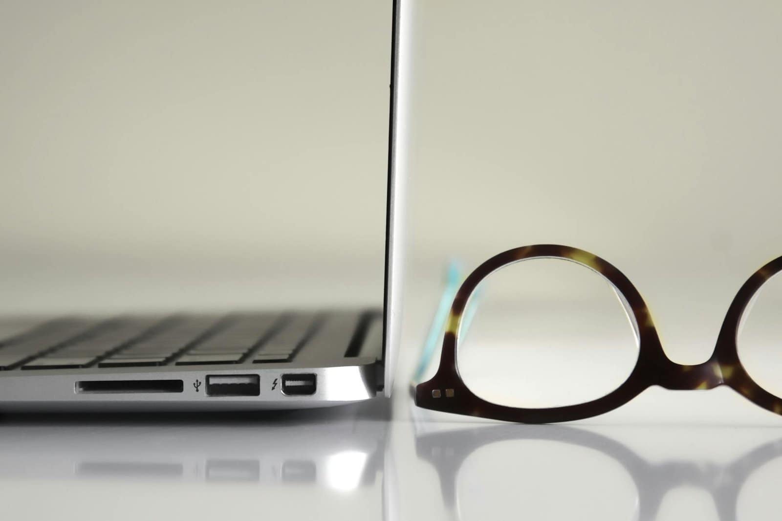 black framed eyeglasses beside laptop computer