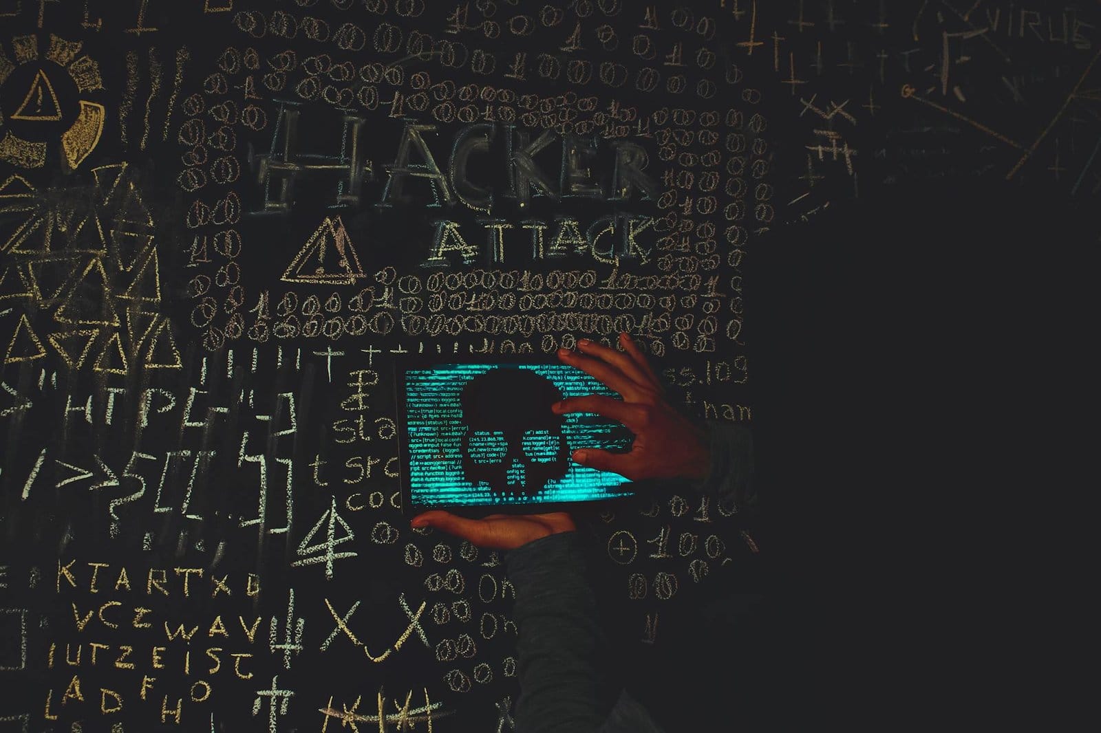 a person holding a tablet device with skull image near blackboard