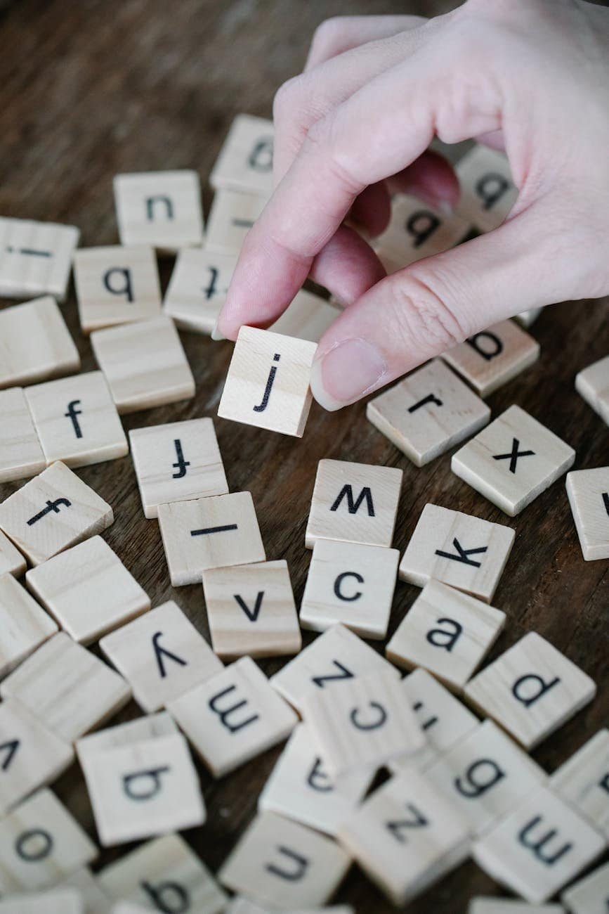 person holding a wooden scrabble tile